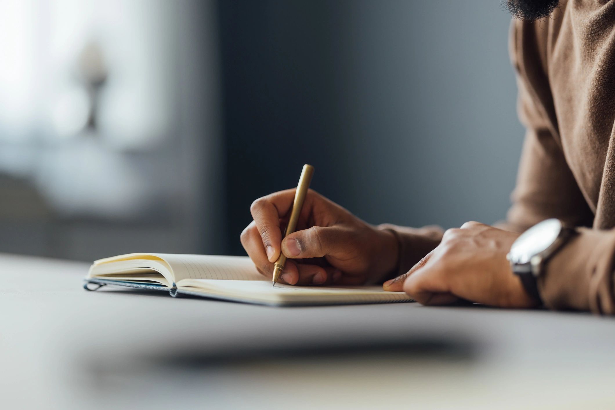 Business owner writing goals and next steps in a notebook
