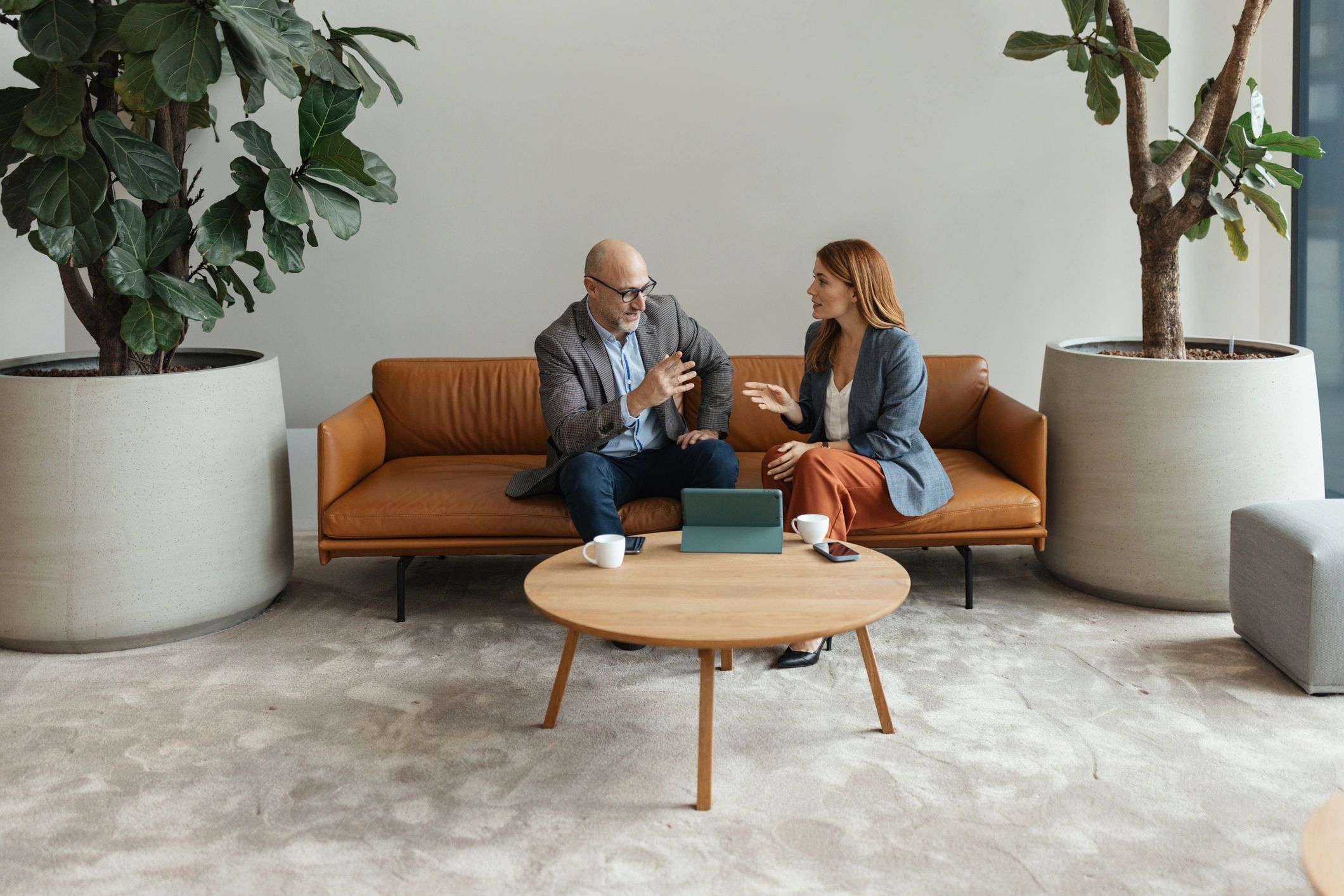 Two professionals reviewing plans together during a coaching-style discussion