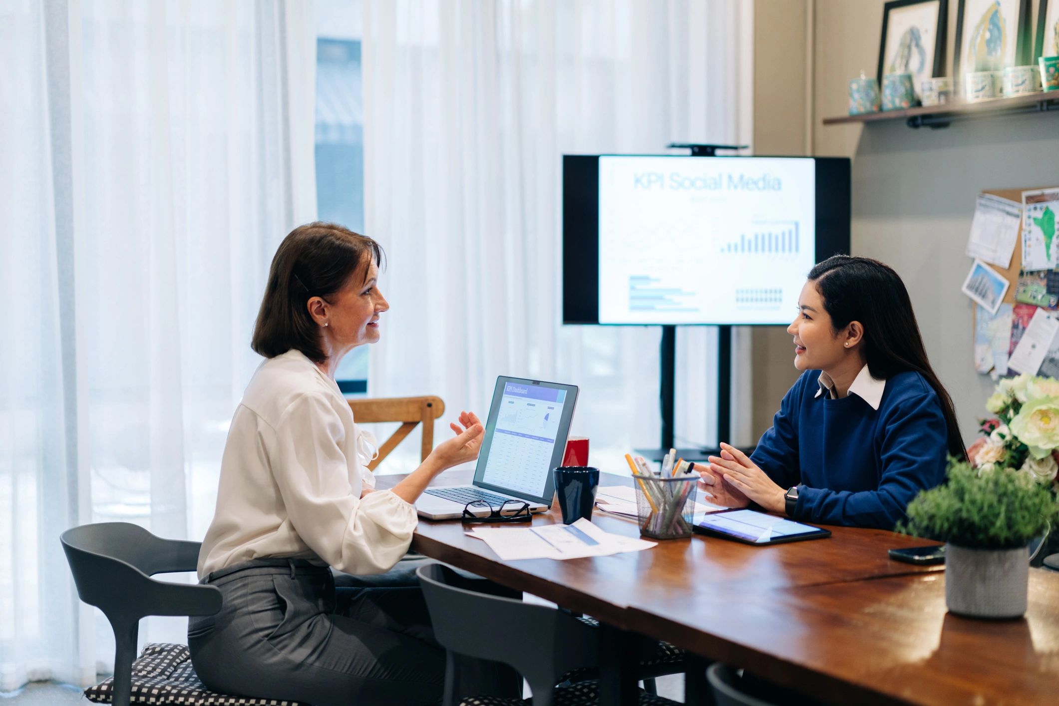 Two professionals in a focused coaching conversation at a desk